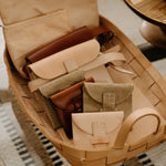 Basket with leather wallets on a woven surface