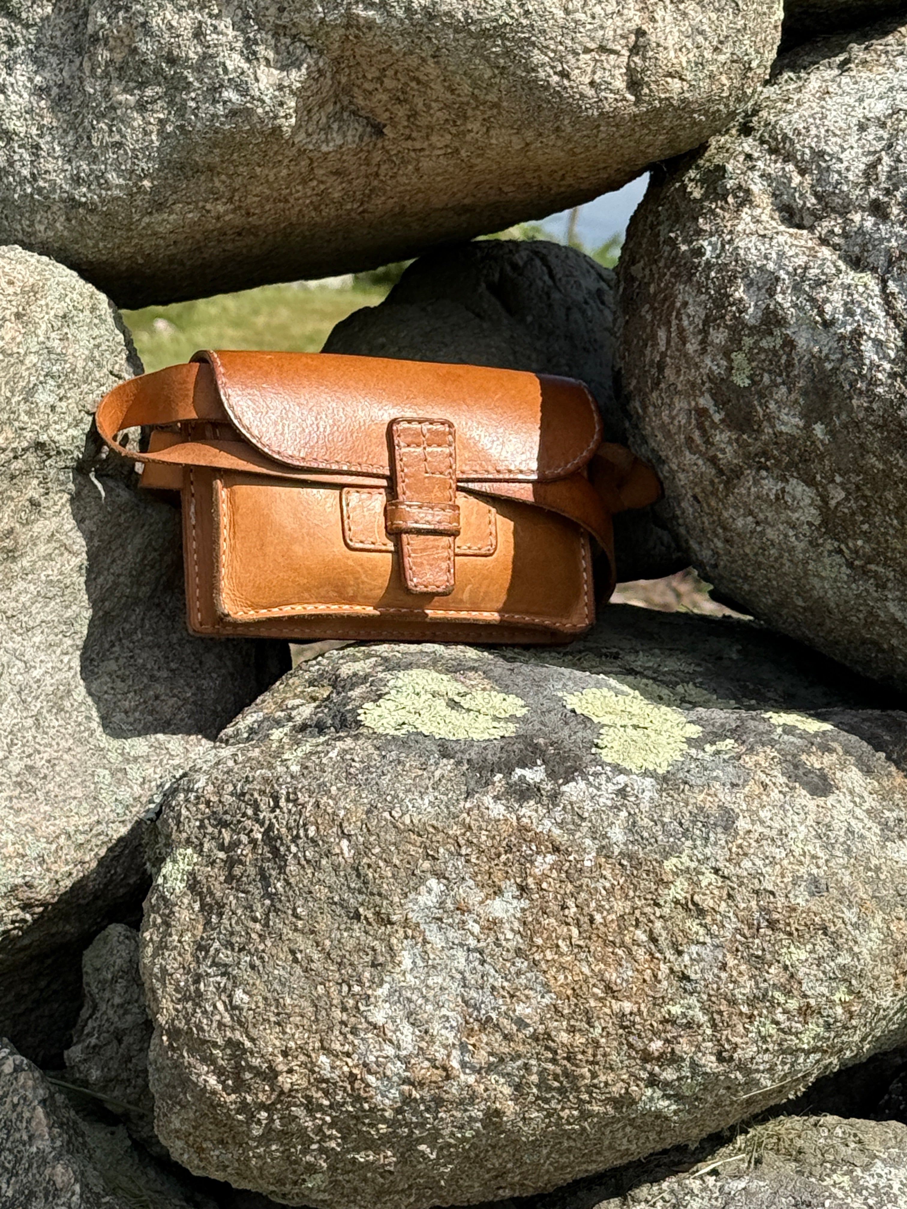 Brown leather satchel on a pile of rocks