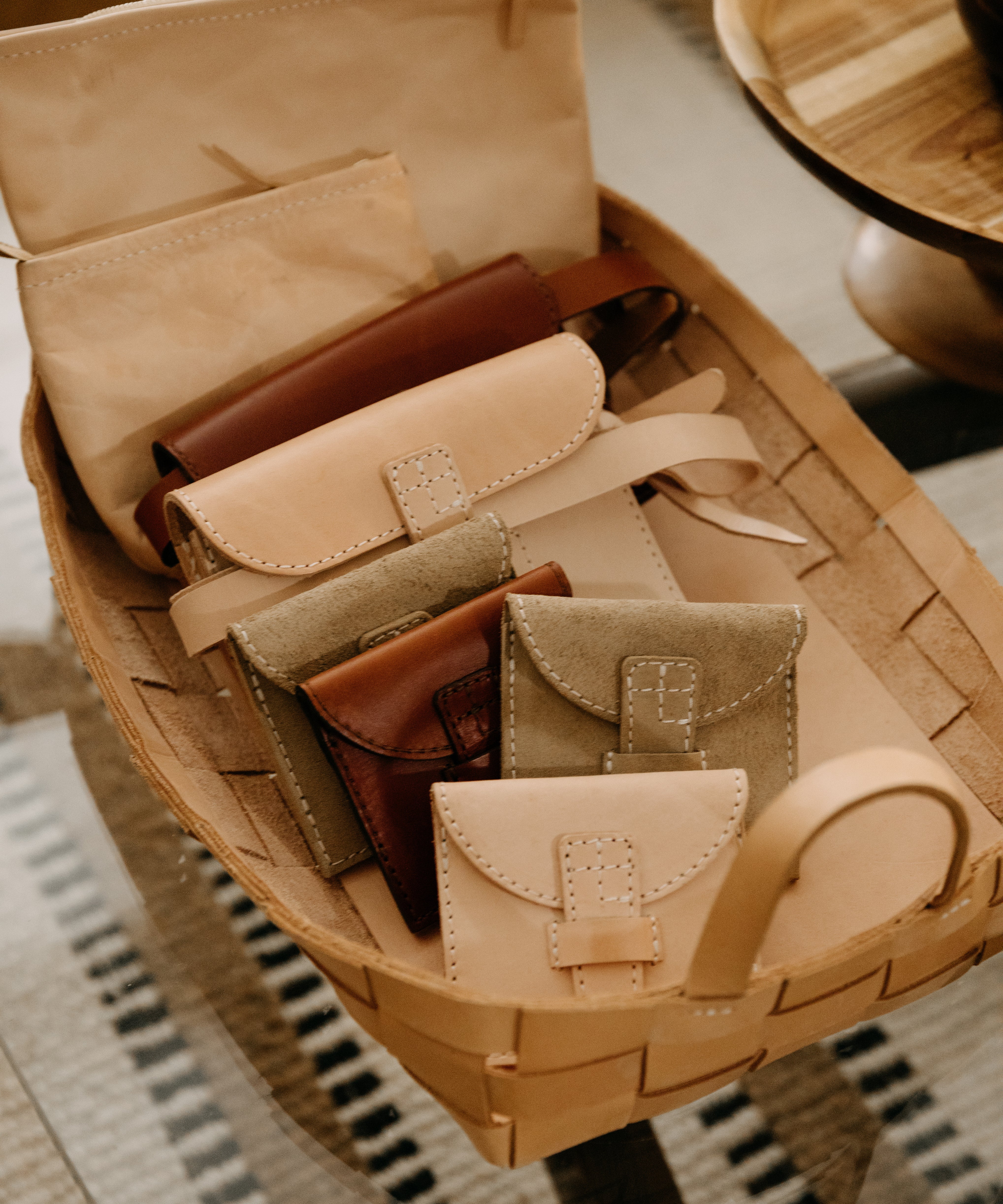 Basket with leather wallets on a woven surface