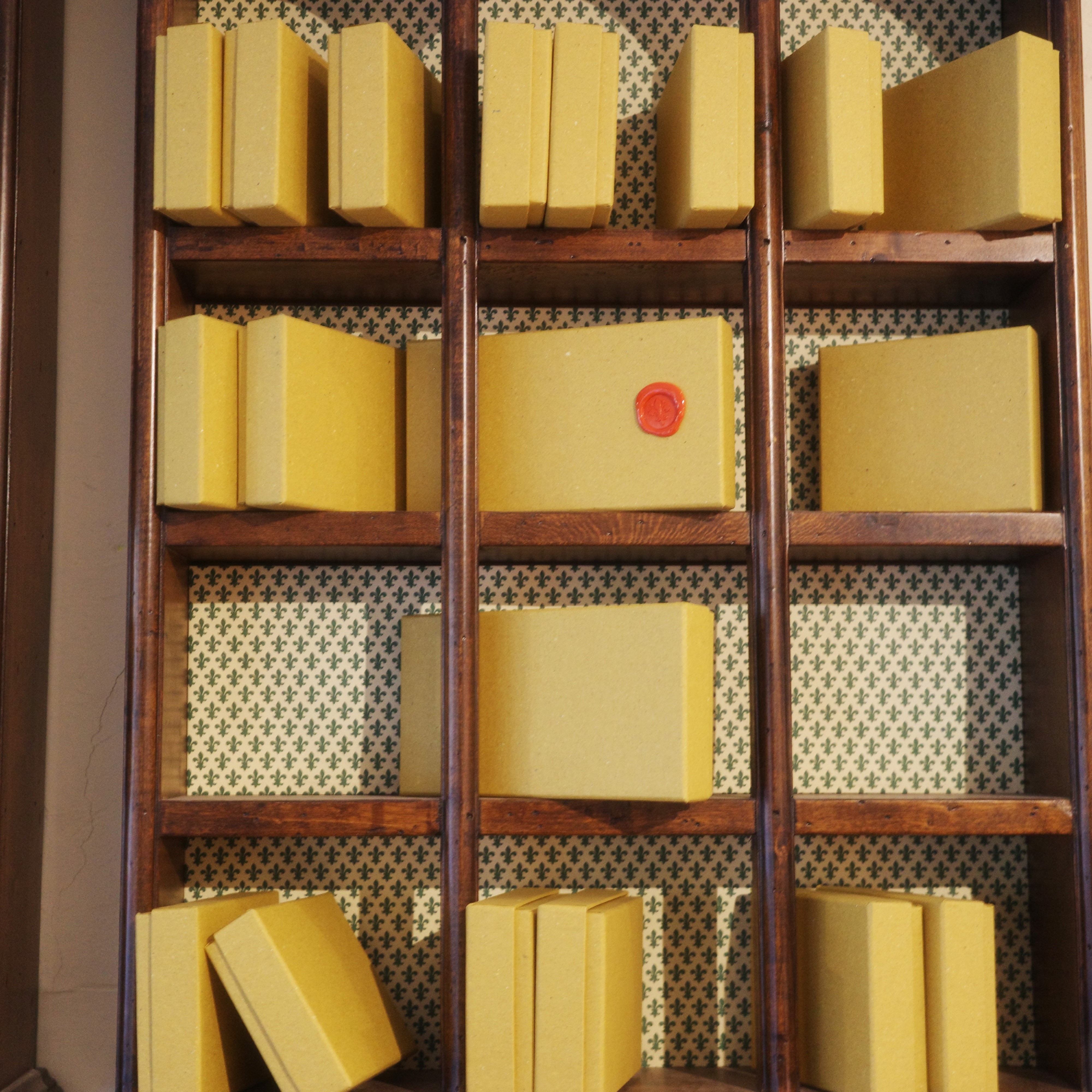 Wooden bookshelf with yellow books against a neutral background